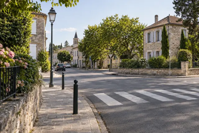 Illustration IA : Un carrefour calme et un passage piéton dans une rue résidentielle fictive.