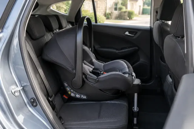 Illustration IA : Un siège enfant vide est visible à l’arrière d’une voiture stationnée.